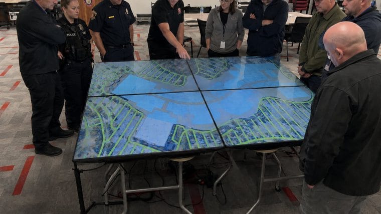 Responders gathered around the Counterstrike Terrain digital map table during a training exercise